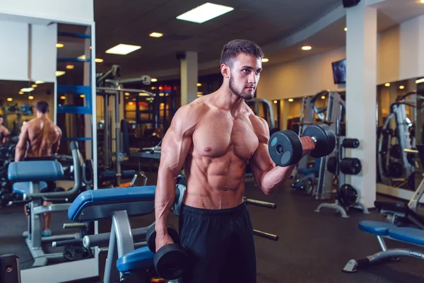 Very power athletic guy bodybuilder , execute exercise with dumbbells