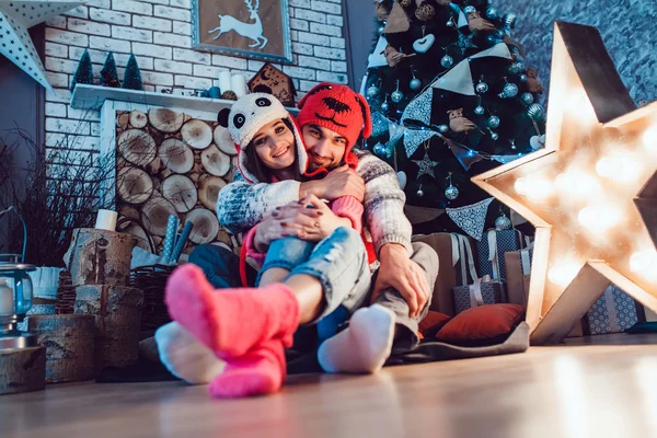 A loving couple in funny hats posing in Christmas decorations