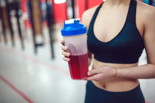 Girl in the gym holding a sports nutrition
