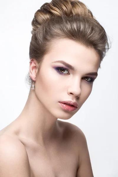 Beautiful girl in an image of bride with a bundle of hair and gentle makeup. Beauty face