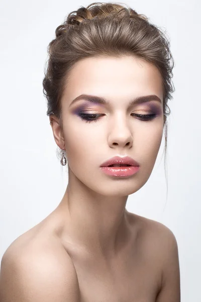 Beautiful girl in an image of bride with a bundle of hair and gentle makeup. Beauty face