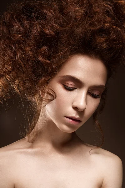 Beautiful redhead girl with curls and classic make-up. Beauty face