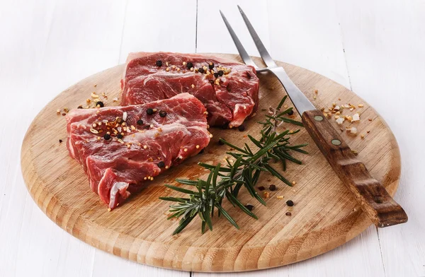 Red meat and rosemary over white background
