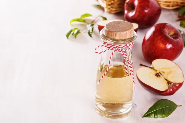 Apple cider vinegar over white wooden background