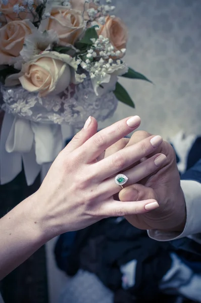 Groom is wearing wedding ring on the bride\'s finger