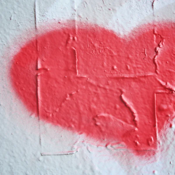 Pink heart shaped symbol on the concrete wall.