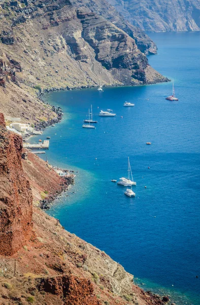 Sailboats and yachts near volcanic rocks of Santorini island, Greece