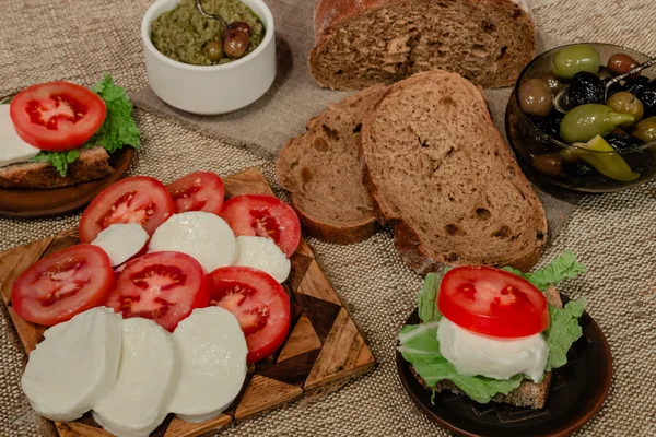 Italian food mix - mozzarella, tomatoes, olives, olive paste and bread