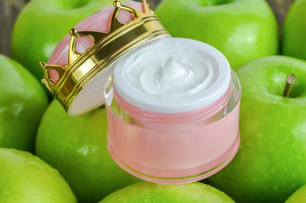 Jar of natural skin care opened on green Apples
