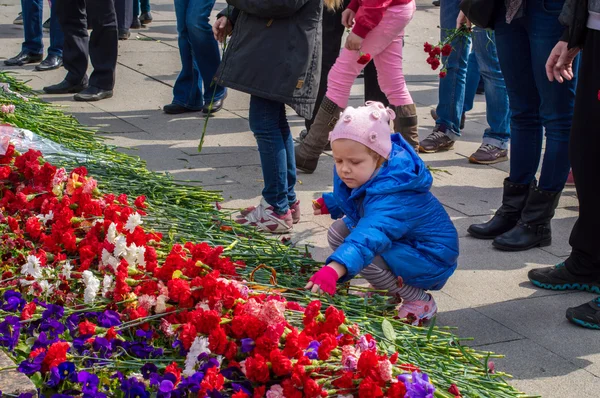 2014. Russia, St. Petersburg - MAY 9: day of victory, memory of heroes. The memory of soldiers in Great Patriotic War.   little girl brought flowers to the graves of the soldiers of World War II