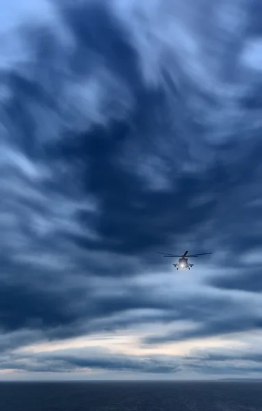 Storm at sea, Mi-8 helicopter from below in front dramatic sky,