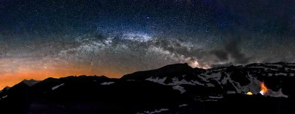 Camping in tent at night under Milky Way stars panorama