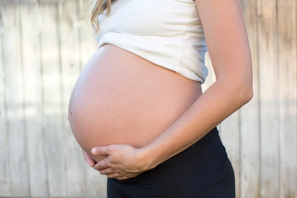 Pregnant woman holding belly