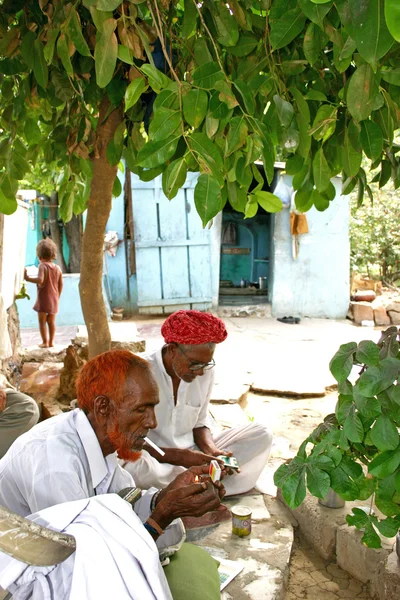 Kerala,India - July 13, 2004: Indian old men smoking under the tree.
