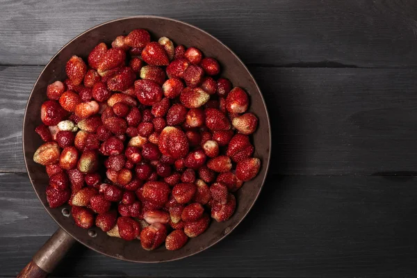 Fresh strawberries into rustic brass bowl