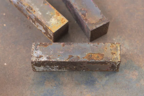 Macro of rusty metal bar on top of rusty metal table background