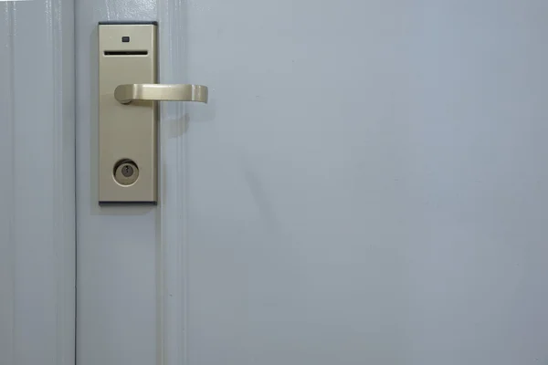 Abstract silver electronic door handle over white hotel door background