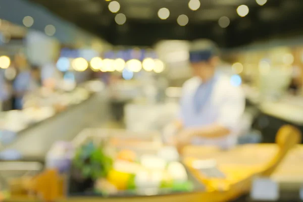 Abstract blurry japanese sea food counter with chef preparing food