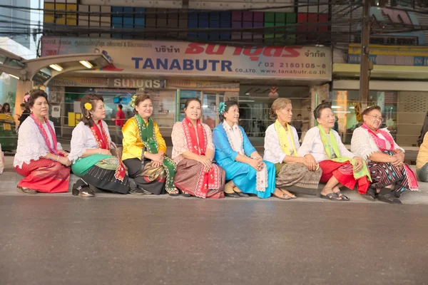 Group of Thai native life style dressing people sit and wait for opening time at Pathumwan intersection in \