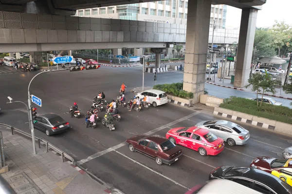 Various vehicles break law by stop car beyond the white line on the ground during red light. This is typical behavior of people when traffic police is not strictly enforce the law