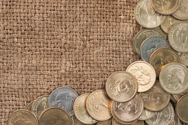 Group of one dollar coins copyspace over used old sack background