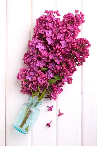 Lilac branch with glass bottle