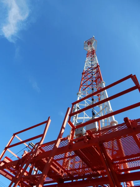 Telecommunication tower red and white with blue sky background