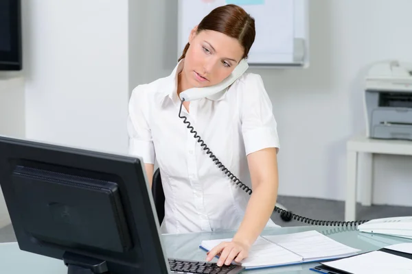 Beautiful woman speaks at telephone in office