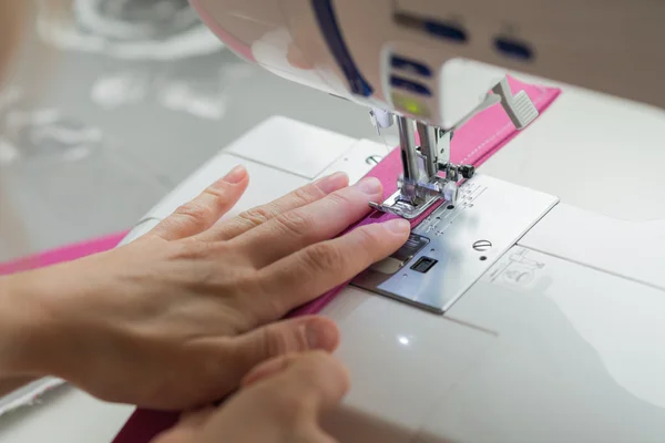 Close woman hands sewing on sewing machine