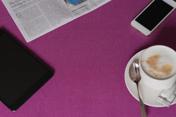 Frame of morning coffee with milk foam , newspaper, tablet and s