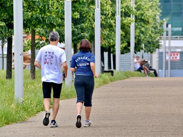 Rear view of senior couple jogging in park