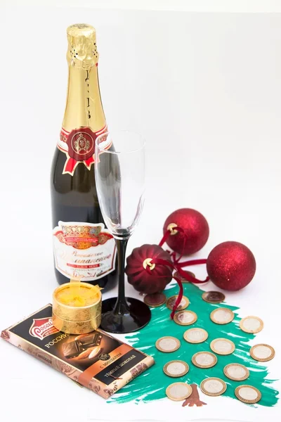 Champagne with glass and red New Year\'s toys on a white background