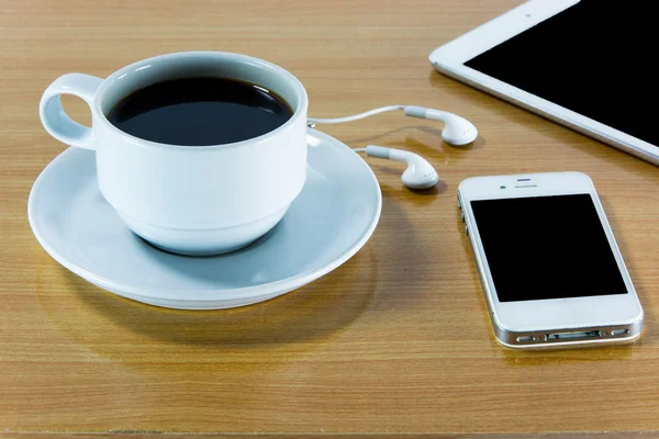 Digital tablet computer with  cup of coffee on old wooden desk.