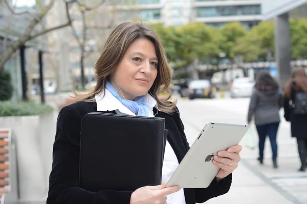 Business woman listening to music with her tablet.