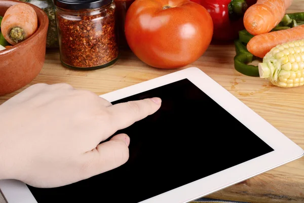 Person preparing food from recipe on tablet.