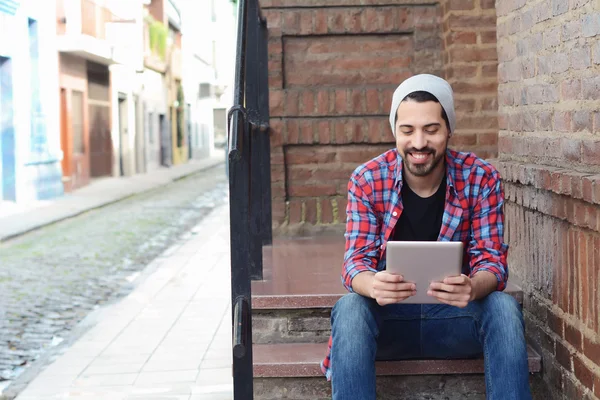 Latin man using a tablet.