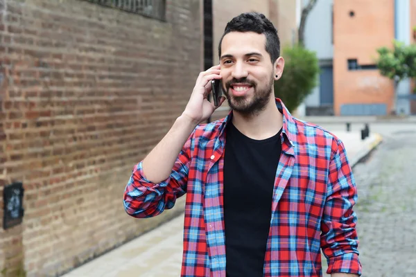 Young latin man talking on the phone.