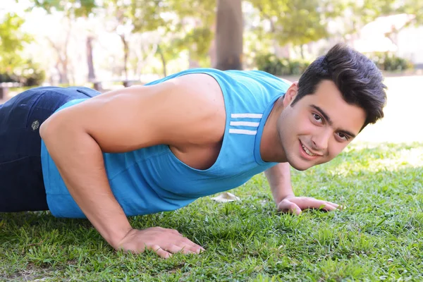 Young man doing push ups at the park