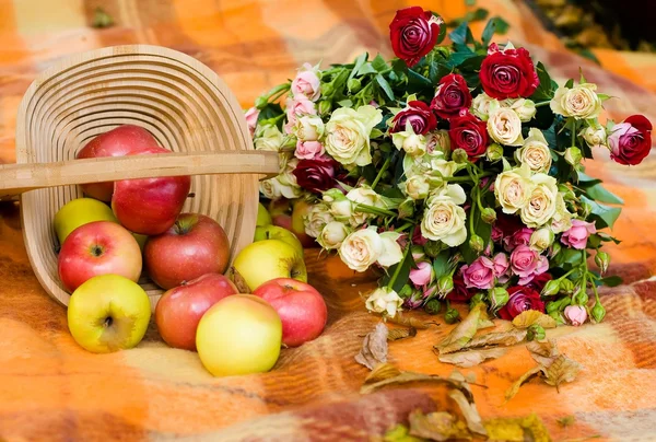 Inverted basket with apples and bouquet of roses