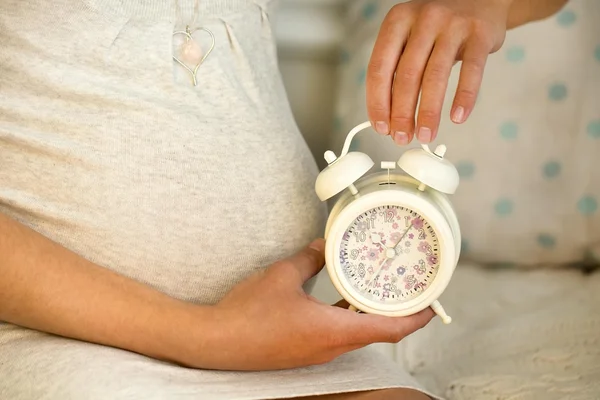 Image of pregnant woman with clock