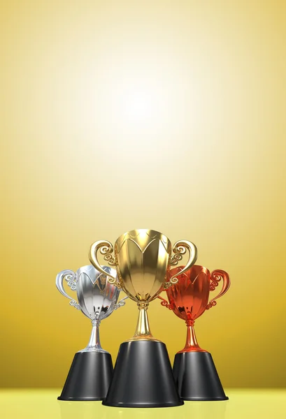 3D rendering gold, silver and bronze  awards winners cup sitting on   yellow tone background. Three cup trophies. Winners cup. Copy   space on top.