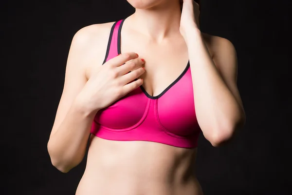 A close up of a sporty woman posing in sports pink bra with nice breast.