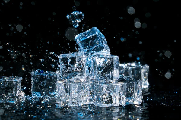 Group of ice cubes with water splashes.