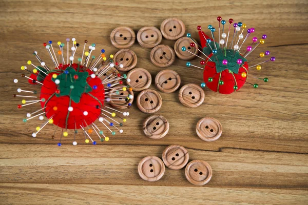 Sewing kit. Colored thread, pins, buttons, ribbons, safety pin.