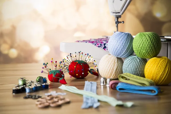 Sewing machine. Colorful threads, needles, pins, buttons.