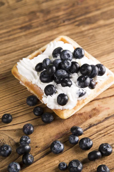 Waffles with whipped cream and raspberries and cranberries,  Waffles with icing sugar