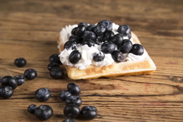 Waffles with whipped cream and raspberries and cranberries,  Waffles with icing sugar