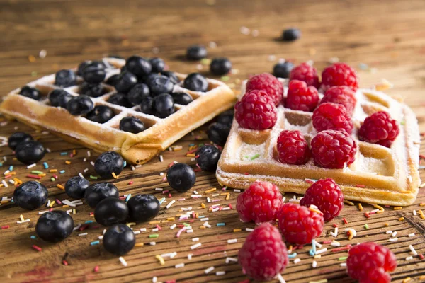 Waffles with whipped cream and raspberries and cranberries,  Waffles with icing sugar