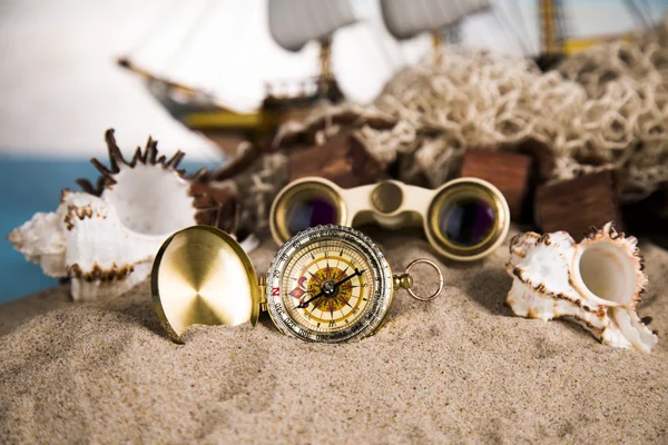 Holiday by the sea, fishing, nets, shells, magnifying glass and binoculars, compass