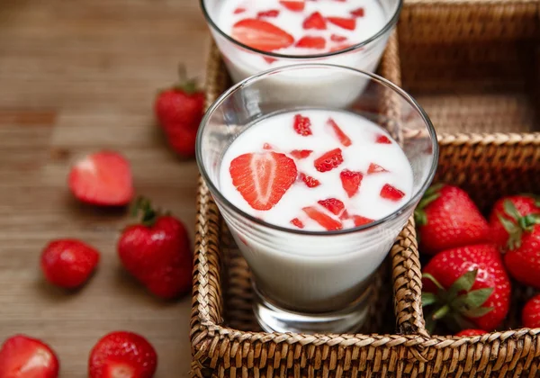 Two Glasses of Yogurt,Red Fresh Strawberries in the Rattan Box on the Wooden Table.Breakfast Organic Tasty Food.Cooking Vitamins Ingredients.Summer Fruits.